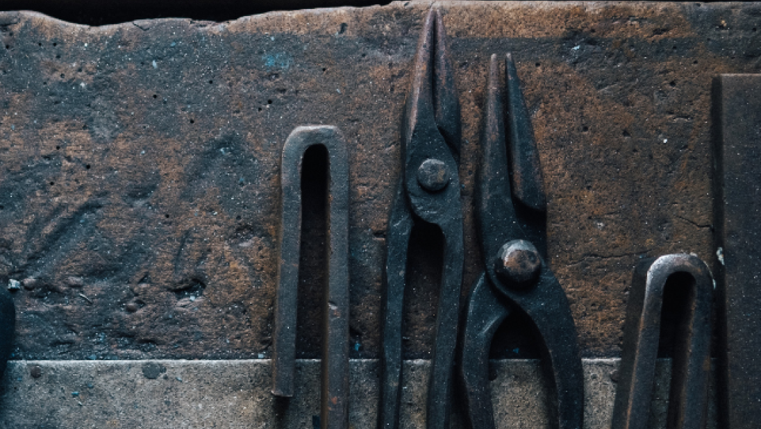 An image of pliers lying on a workshop table.