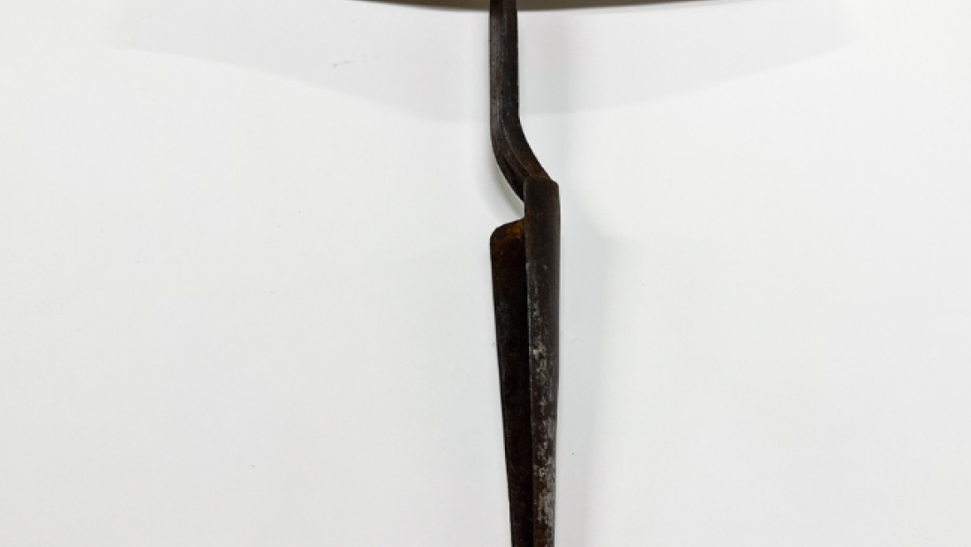 A carpenter's auger, with a wooden handle and a perpendicular metal tool.