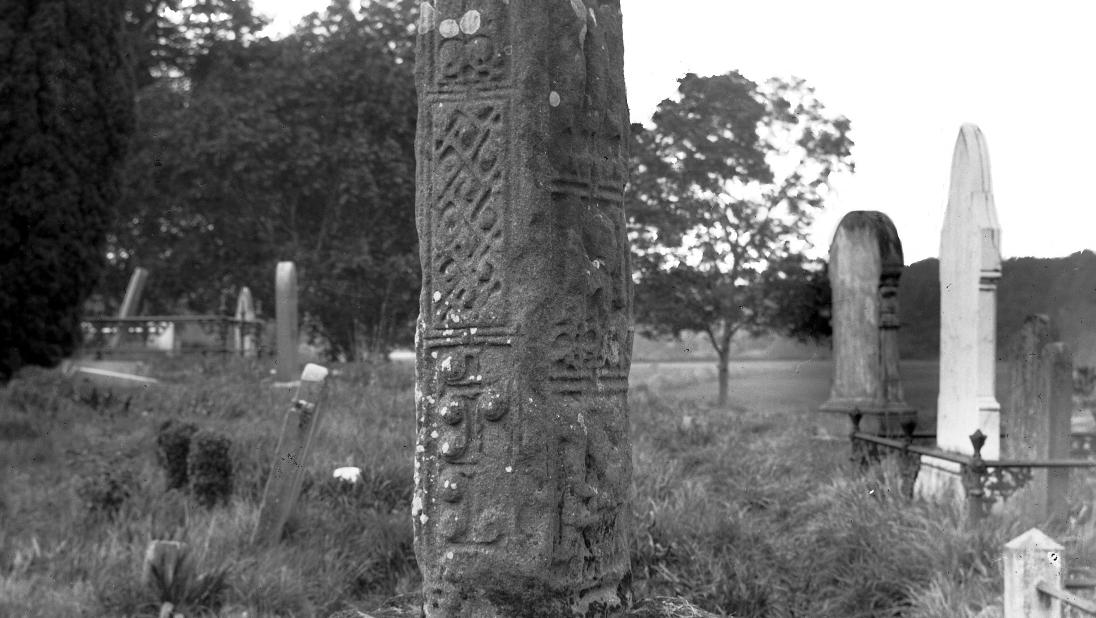 An image of a tall standing stone that has been carved with celtic imagery.