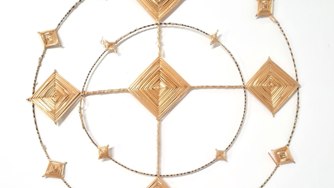A Saint Brigid's Cross. The cross is shaped like a halo, with two rings around a diamond shaped centre.