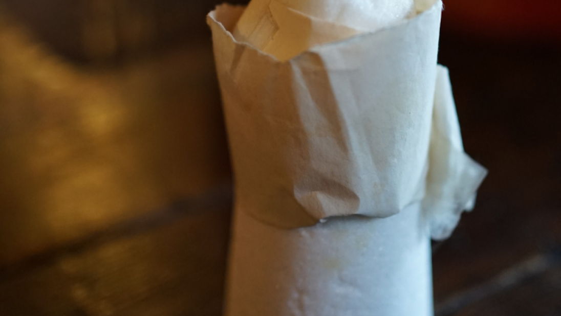 A sugar cone wrapped in paper.