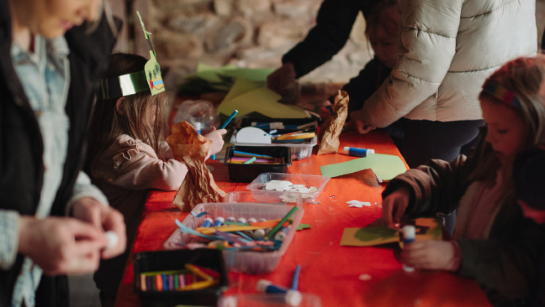 a group of adults and children doing crafts