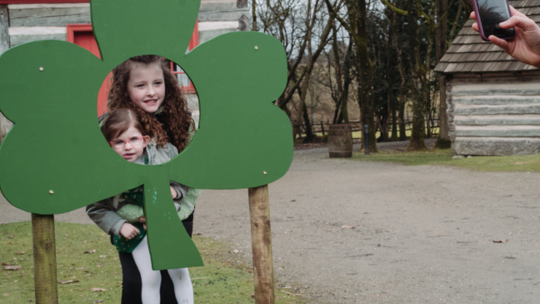 two kids smiling inside a shamrock selfie station