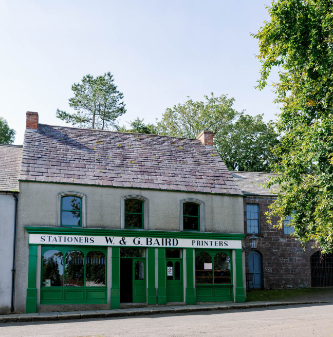 A two-storey building. The ground floor has a green facade with the sign 'W & G Baird' painted on.