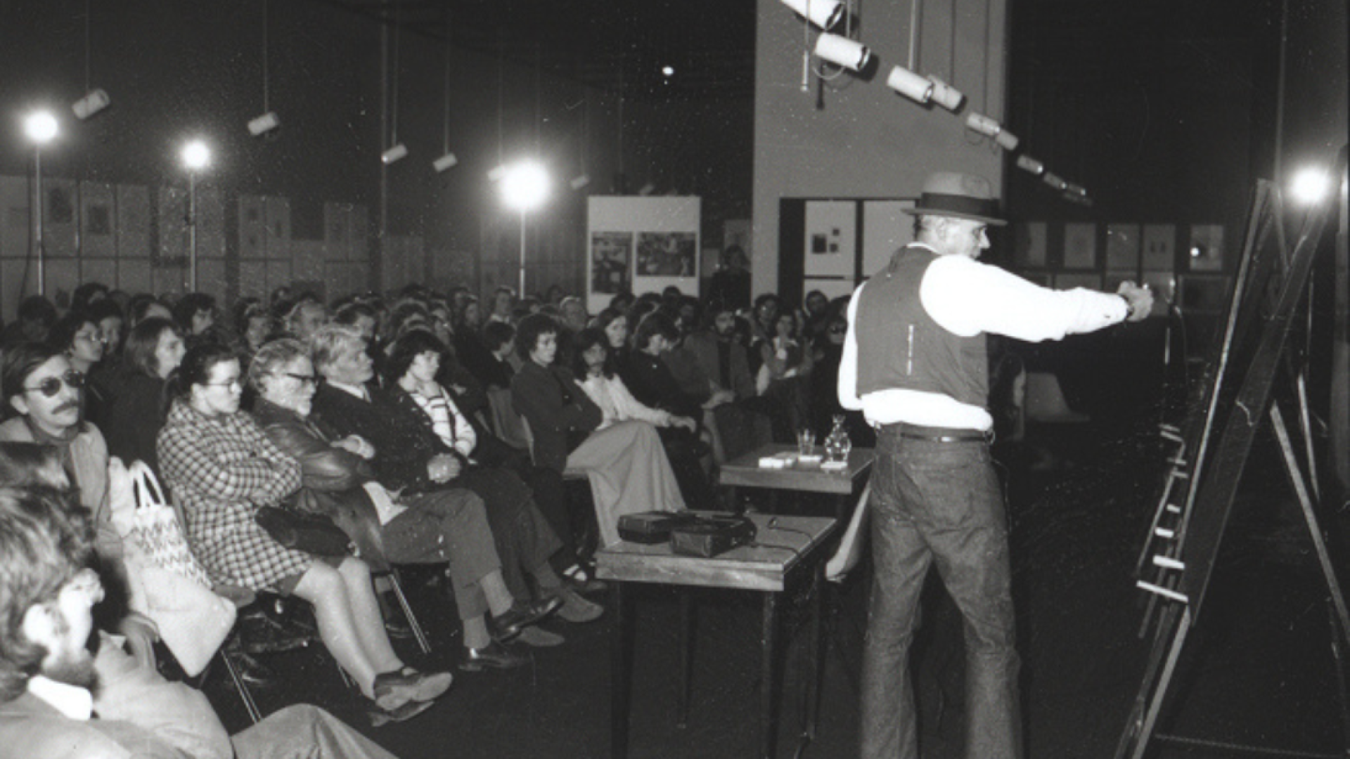 A photograph of the artist Joseph Beuys giving a lecture at the Ulster Museum.