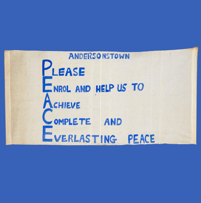 A banner from a peace march that reads, 'Andersonstown, Please Enrol and help us to Achieve Complete and Everlasting peace'.