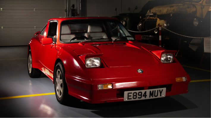 Red Clan Clover car in a darkened garage with artificial lights
