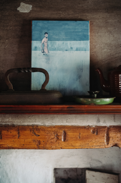 Art on display above fireplace inside exhibition house