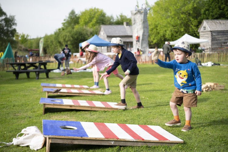 Young kids playing cornhole
