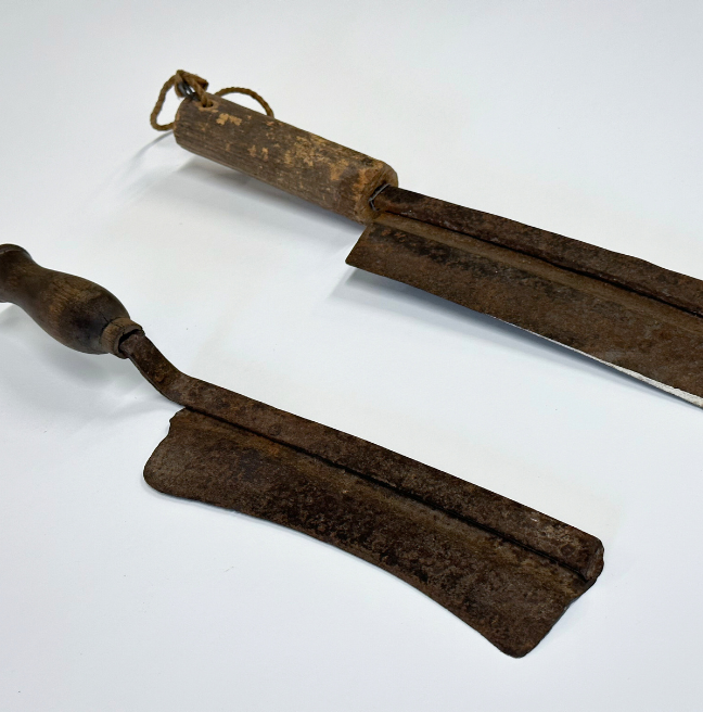 Two thatching knives on their sides.