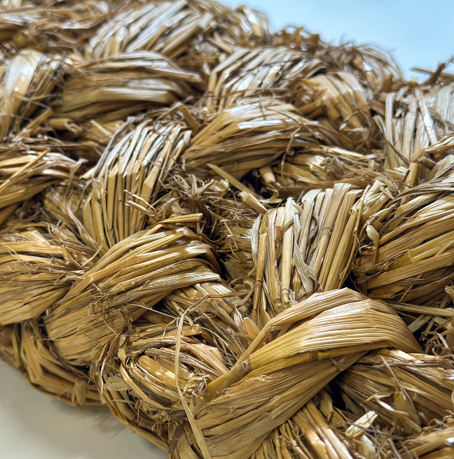 Close-up of a woven mat with hay-like material.