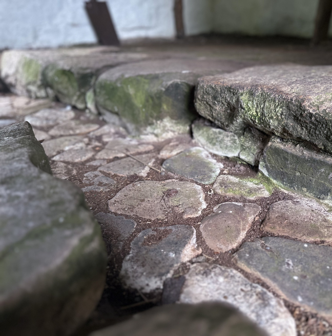 A close up of a small stone ditch that runs through Magheragallan Byre Dwelling.