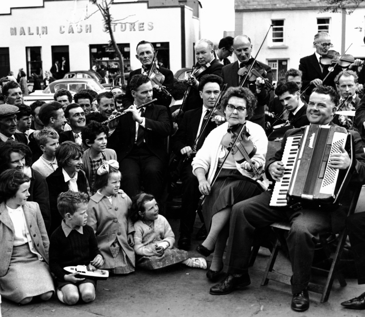 A band plays in a crowded town street.