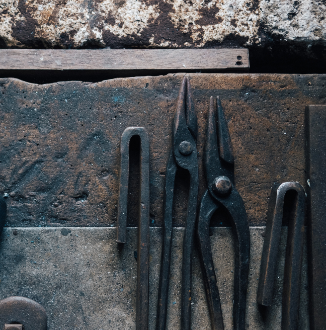 An image of pliers lying on a workshop table.