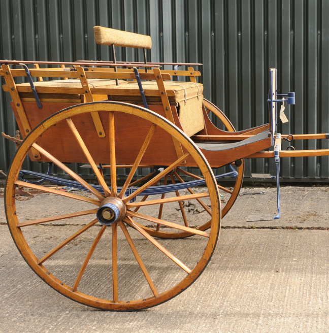 A wooden carriage for attaching to a horse.