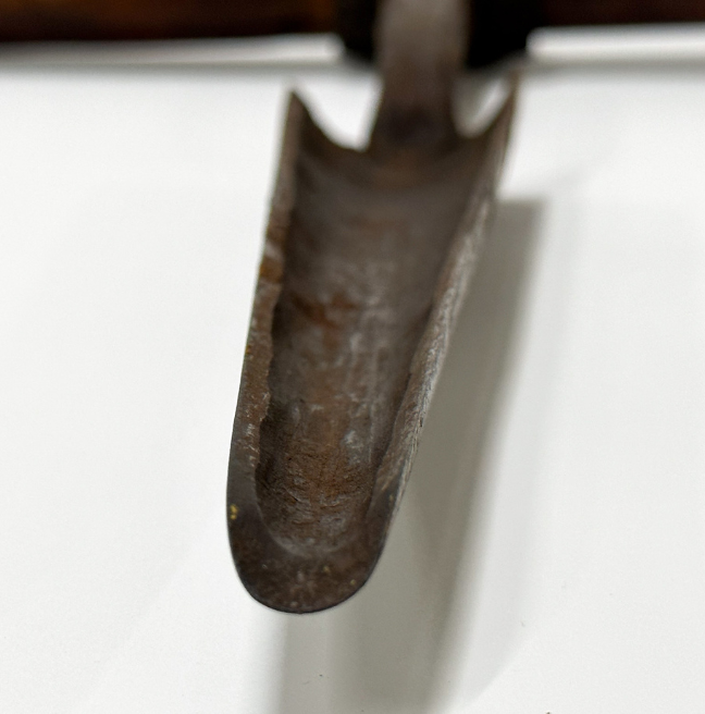 A close up of the metal end of an auger.
