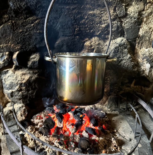 Potatoes boiling in a pot over a fire