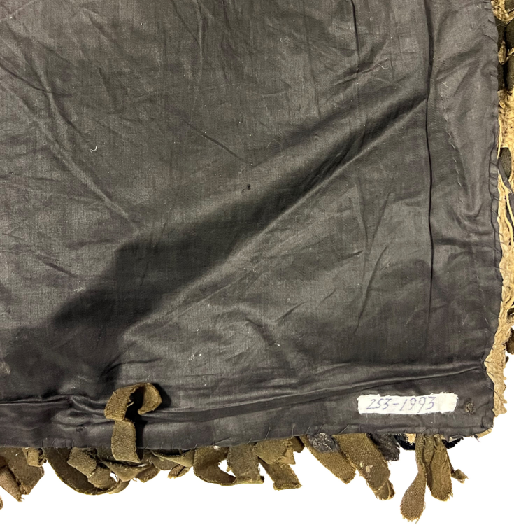 The back of a rug that has been covered with a dark fabric.