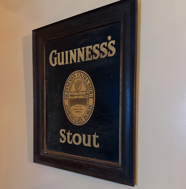 A framed advertisement for Guinness, reading 'Guinness's Stout'. The advertisement is based on an old Guiness advertisement.