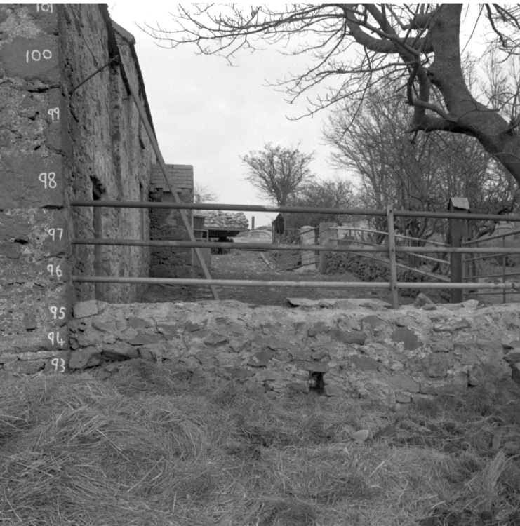 A black and white photograph of a farm building with its bricks numbered.