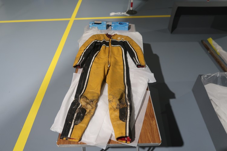 A yellow and black racing jumpsuit stretches out on a tabletop.