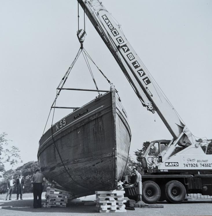 Black and white photograph of the Mary Joseph nickey boat being moved by a crane