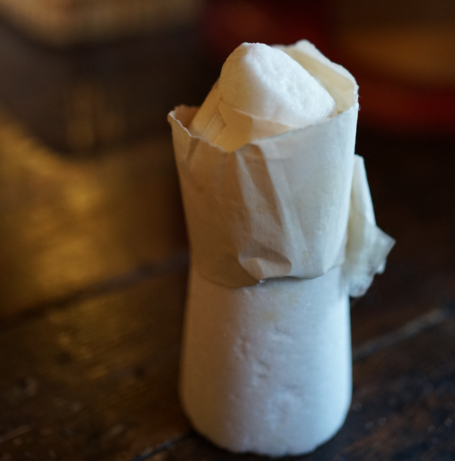 A sugar cone wrapped in paper.
