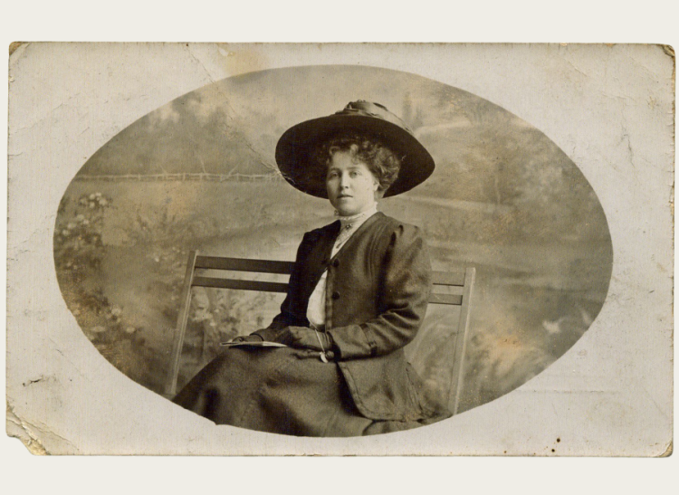 A black and white photo of a woman sitting on a bench.
