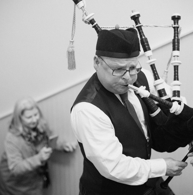 Black & white image of a man playing pipes