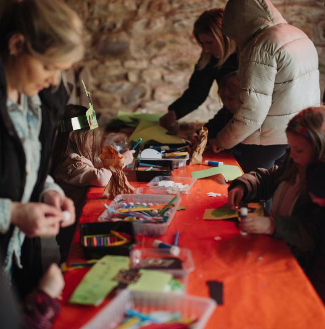 a group of adults and children doing crafts