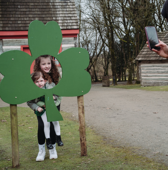 two kids smiling inside a shamrock selfie station