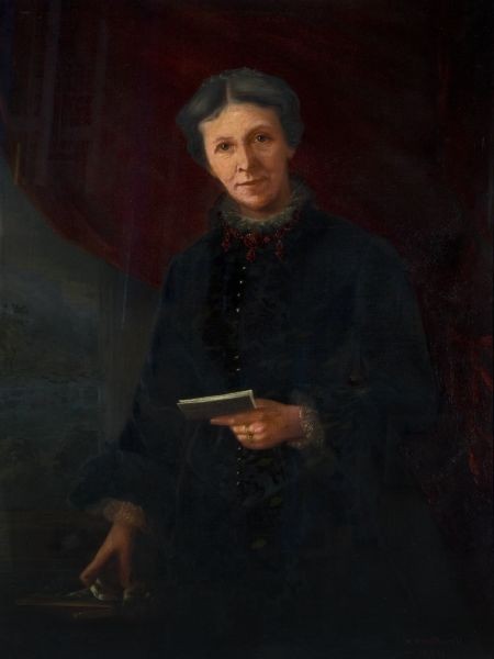 A portrait of a woman holding a book. She is wearing a dark dress, with sleeves and a high neckline. She is seated.