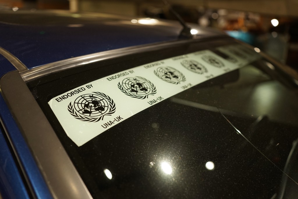 An image of a windshield. There is a decal stretching across the top with the repeated UN logo.