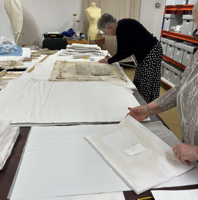 Two people work on lace in our textile store.